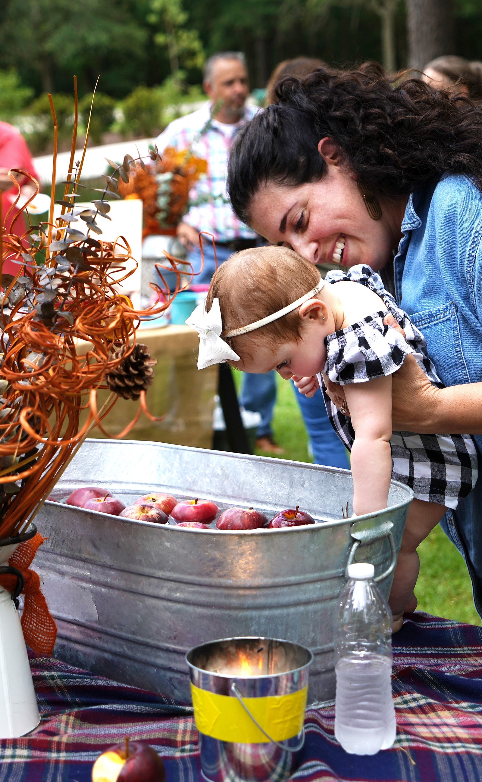 Jeanette laughing with a toddler at an outdoor party