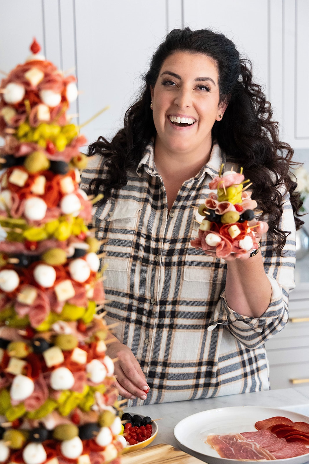 Jeanette laughing in her kitchen, holding a mini antipasto tree