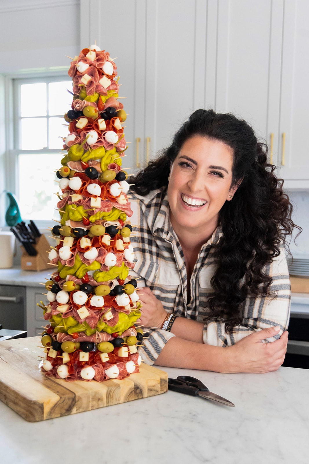 Jeanette laughing beside a tower of skewered charcuterie